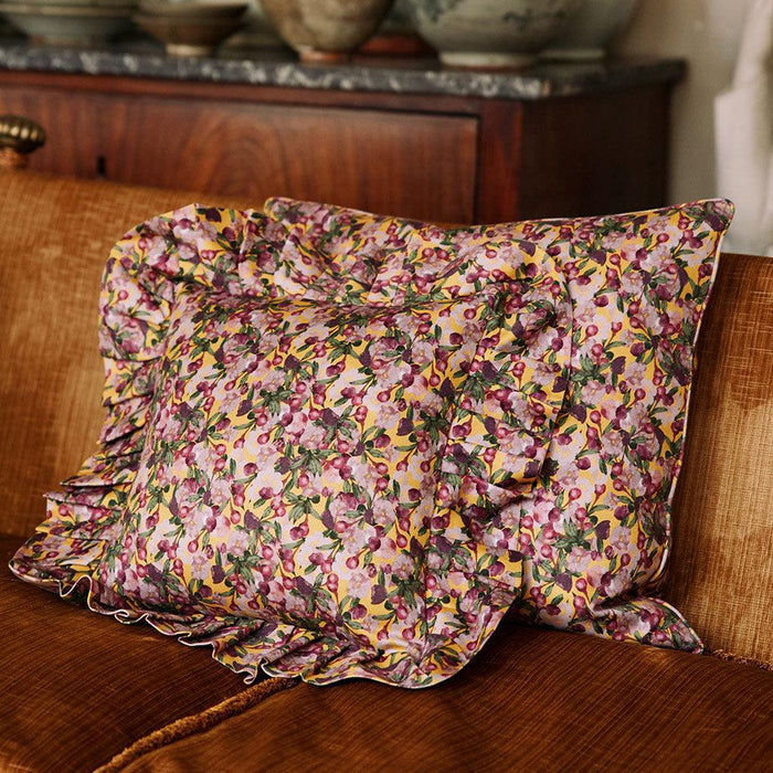 Styled view of the Romance Is Dead Organic Cotton Square Pillow Cover in Yellow
