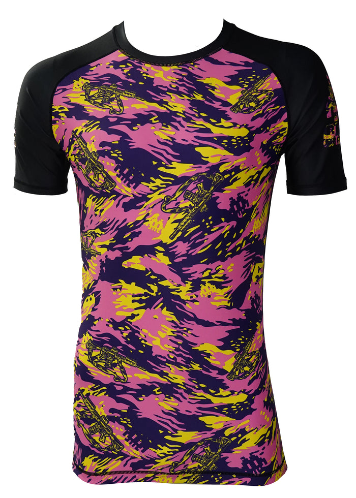 The Retro Grappler Thai Tiger Stripe Camo Kit is a short-sleeve athletic rash guard with black sleeves and a dynamic pink, yellow, and dark blue abstract front. Motocross bike graphics add energy throughout the design.