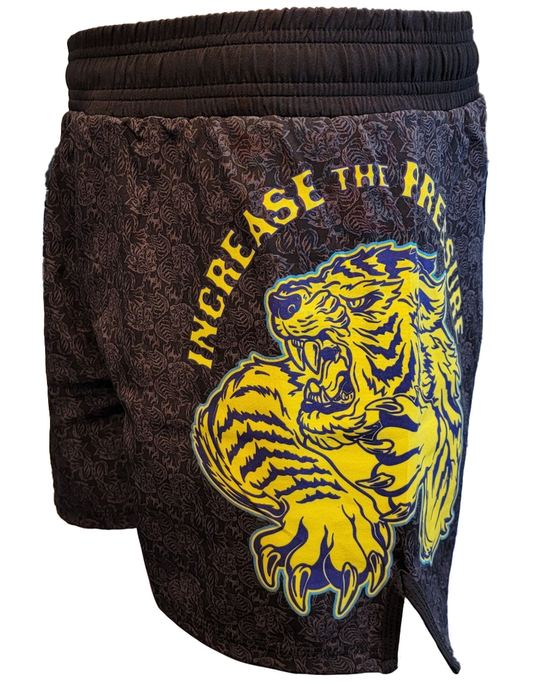 Retro Grappler’s Tiger Pressure Grappling Shorts are black, lightweight, and feature a yellow-blue roaring tiger with “INCREASE THE PRESSURE” above it, an intricate patterned fabric, and a no-Velcro closure for comfort.
