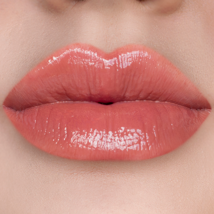 Vibes warm nude coral lip gloss on lips, light skin tone