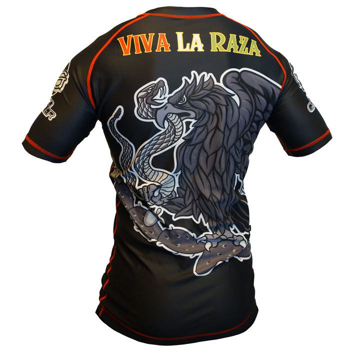 The Retro Grappler Viva La Raza Mexico BJJ Rash Guard is a black athletic shirt with red trim, a bold eagle and snake graphic on the back, and VIVA LA RAZA in yellow—ideal for jiu jitsu and combat sports fans.