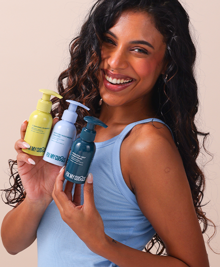 A model is posing with Wash Day Bundle products of Fix My Curls