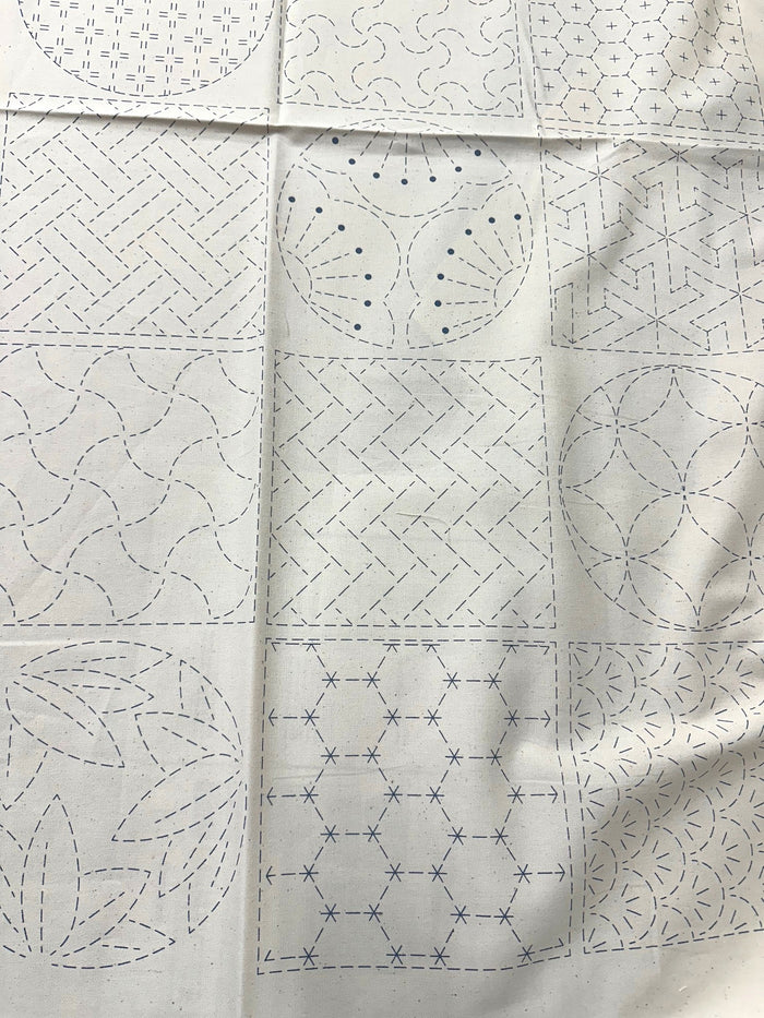 cream colored fabric with sashiko design squares printed on it.