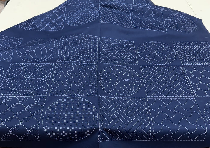 Sashiko fabric with white geometric patterns on a blue background