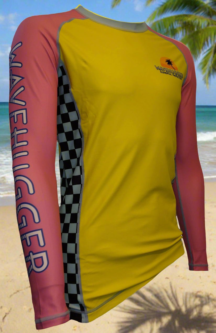 The Wave Hugger Classy and Nasty Rash Guard features long yellow sleeves, pink accents, black-and-white checkered sides, a left-sleeve “WAVEHUGGER” print, and a palm tree logo for surf-inspired beach style.