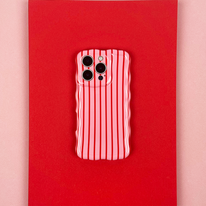 Cherry Stripes wavy phone case by Coconut Lane on a phone, shown on a bold red background.