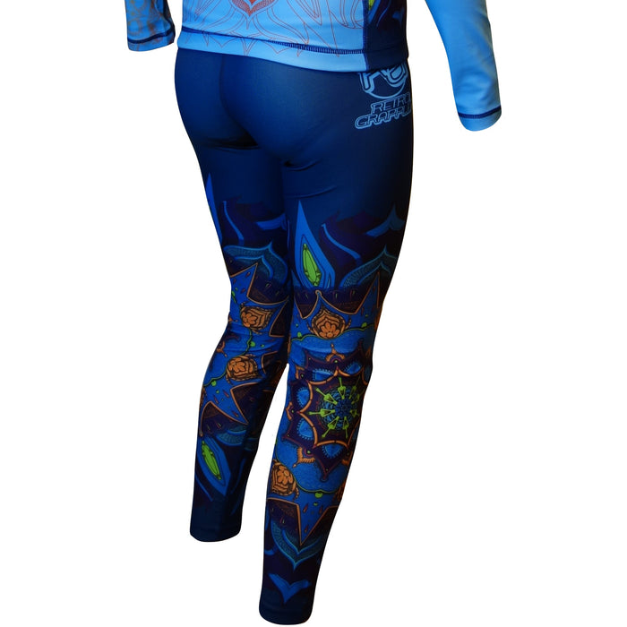 Model wearing Retro Grapplers Zen Line: Mandala Womens Spats, shown from the back, featuring colorful geometric and star patterns. Four-way stretch fabric ensures comfort. White background.